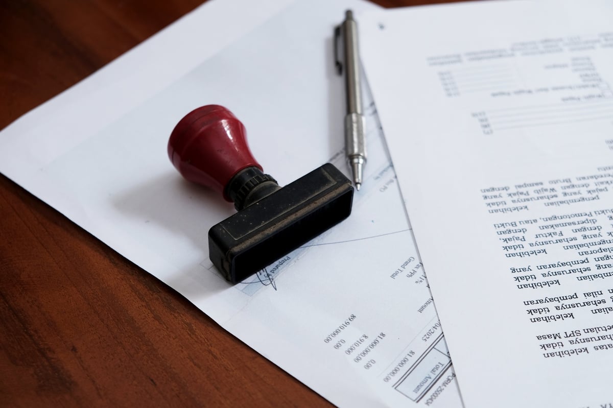A stamp and pen resting on an approved professional document